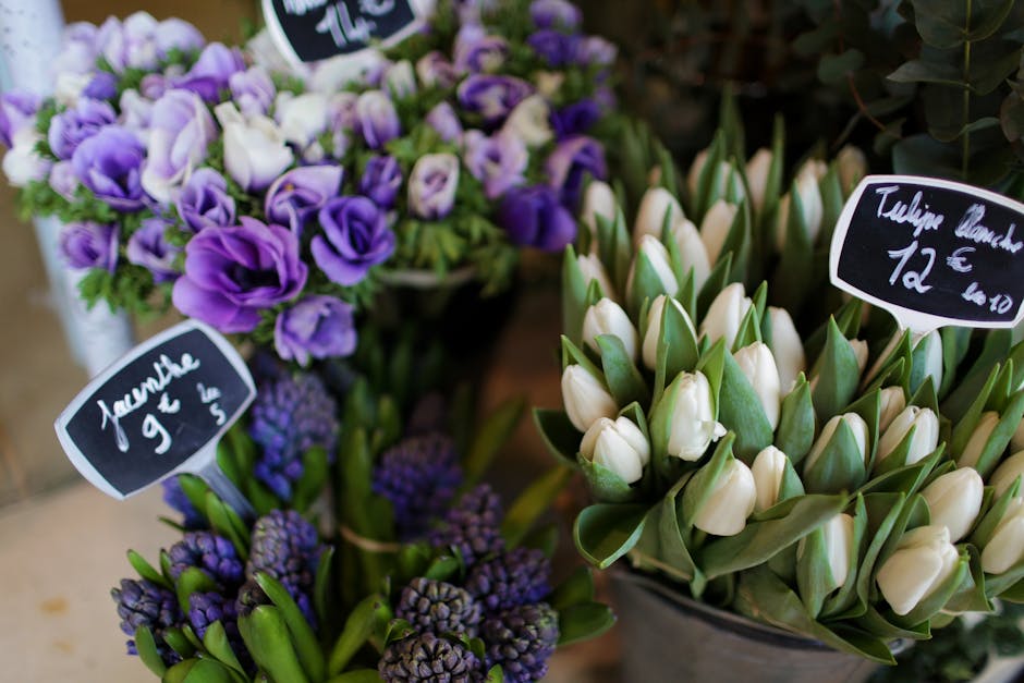 A floral display featuring a bouquet of purple and white freesias with delicate, slightly open petals and lush green stems, arranged with similar-sized purple hyacinths that have densely packed, bell-